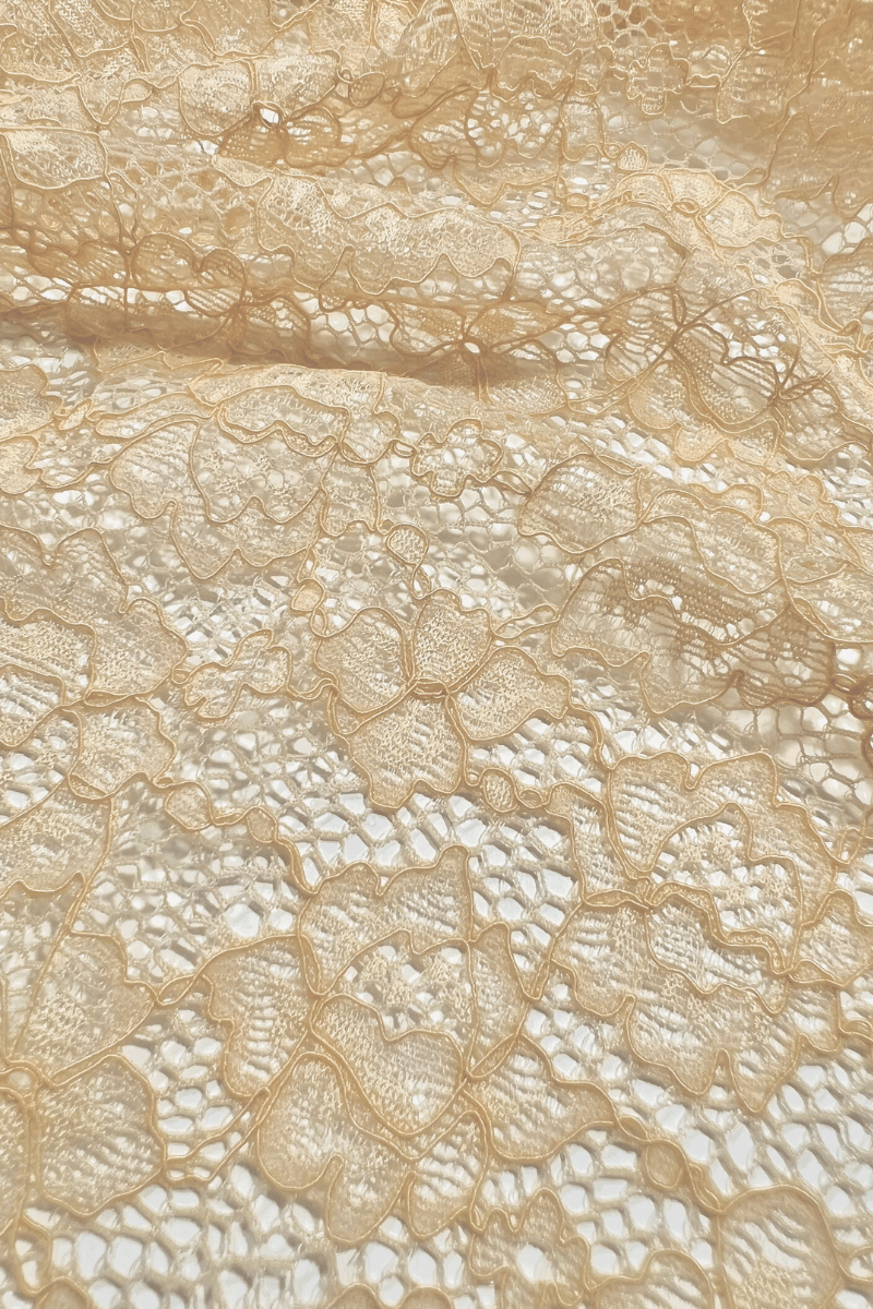 Close up of beige stretch lace fabric used in Ender Legard backless bodysuits