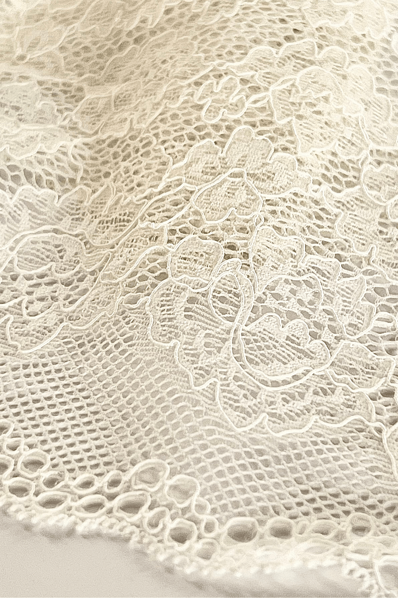 Close up of ivory stretch lace fabric used in Ender Legard backless bodysuits