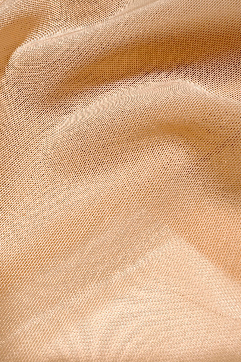 Image of beige power mesh fabric used in Ender Legard bodysuits showing the fine detail of the material